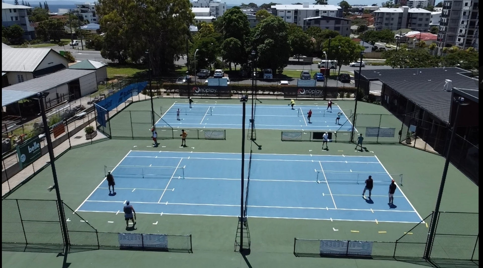 Close dronew shot of Focus Tennis Academy tennis court with players