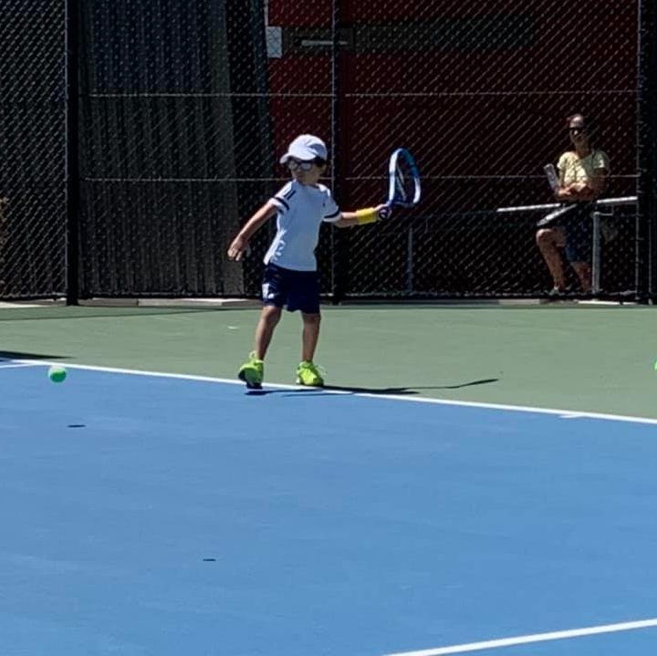 Kid playing tennis on court at Redcliffe Tennis Centre
