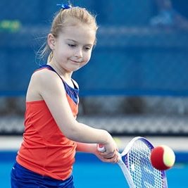 Girl smiling while playing tennis at Redcliffe Tennis Centre