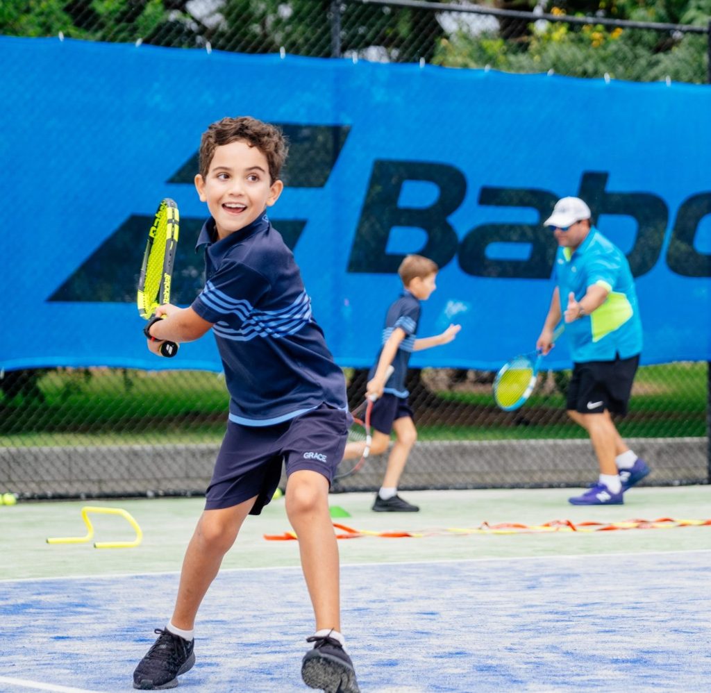 Grace Primary School students playing tennis with Focus Tennis Academy coaches